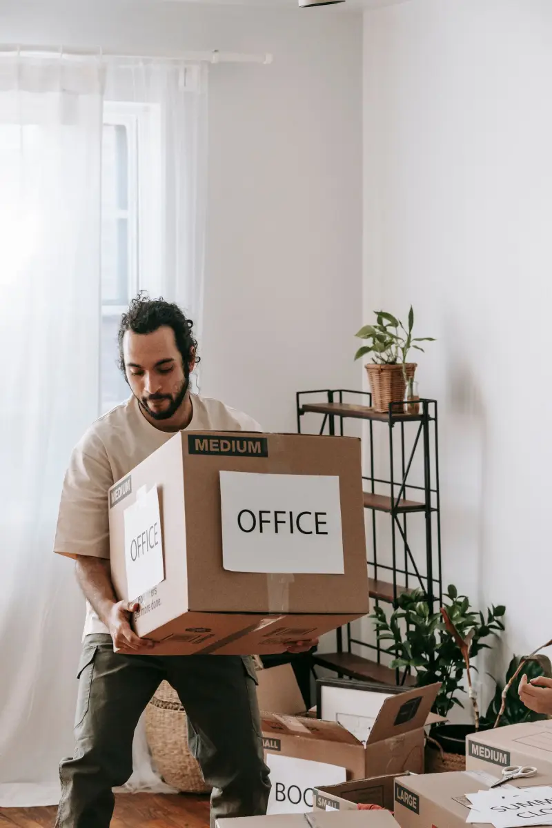 Man carrying a moving box labelled Office