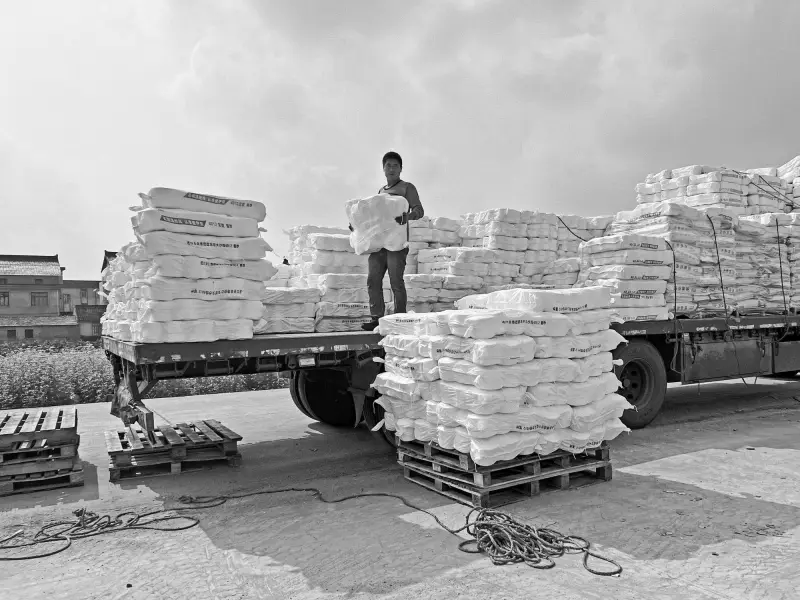 Worker arranging pallets of goods on a flatbed truck